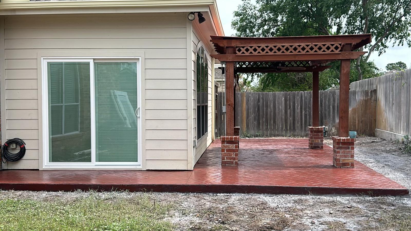 Patio con concreto estampado rojo y pérgola